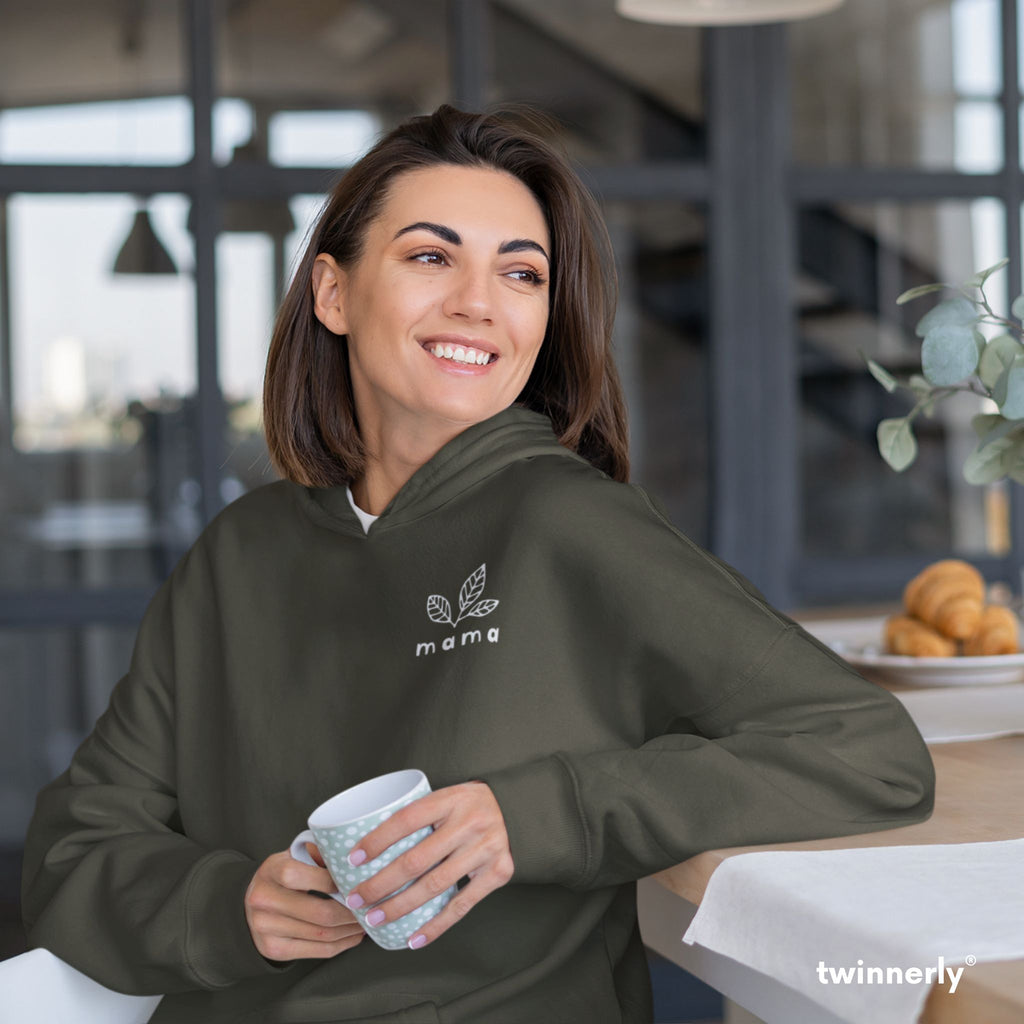 smiling woman holding coffee mug wearing green hoodie